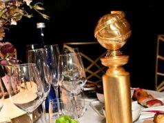 Elegant table setting with sushi, a gold award, and assorted dishes for a sophisticated dining experience.