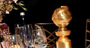 Elegant table setting with sushi, a gold award, and assorted dishes for a sophisticated dining experience.