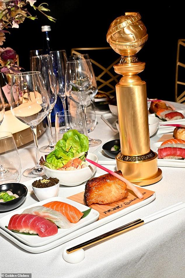 News Room : $125 Golden Globes menu leaves sour taste: Elegant table setting with sushi, a gold award, and assorted dishes for a sophisticated dining experience.