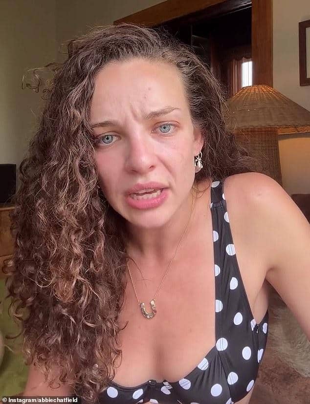 News Room : Abbie Chatfield commits major wardrobe faux pas Upset woman with curly hair and blue eyes in a polka dot dress, indoors, emotional expression.