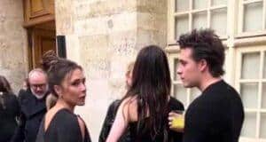 Discussions among stylish young adults at an outdoor event in a historic city setting.