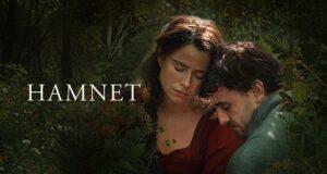 Two actors in a lush garden setting for the production "Hamnet" with a contemplative mood.