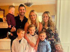 Happy family portrait of parents, kids, and baby celebrating indoors in bright, cozy home.