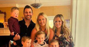 Happy family portrait of parents, kids, and baby celebrating indoors in bright, cozy home.