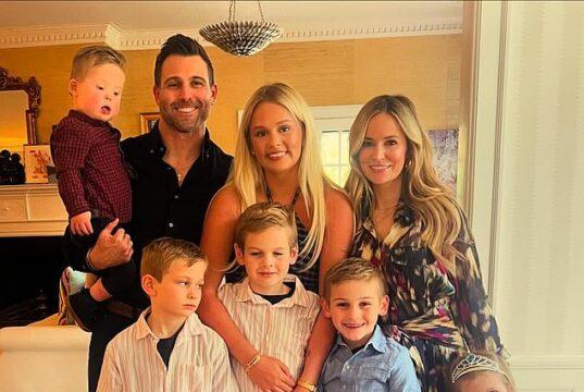 Happy family portrait of parents, kids, and baby celebrating indoors in bright, cozy home.