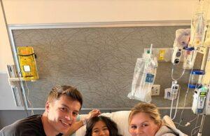 News Room : Bringing Up Bates alum Lawson Bates says he’s ‘always here for’ his sister Katie Clark after cheating scandal Young girl in hospital bed with two smiling visitors, medical equipment in background.