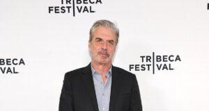 Stylish middle-aged man in black suit at Tribeca Festival red carpet event.