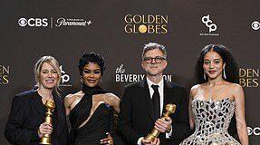 Four award winners posing with their trophies at a prestigious event.