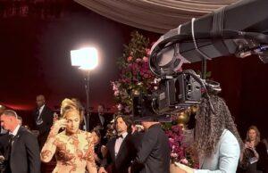 News Room : Jennifer Lopez’s ‘rude’ Glambot moment explained as Cole Walliser breaks silence to reveal what happened Elegant woman in glamorous gown being filmed at red carpet event with professional camera crew.