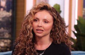 News Room : Jesy Nelson shares new pictures of her twin baby daughters on a walk after opening up about their heartbreaking muscle weakening condition Curly-haired woman speaking passionately on a talk show set.