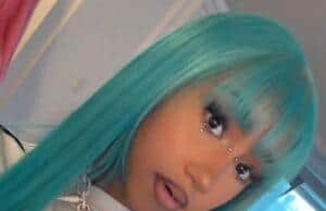 News Room : Kim Kardashian’s daughter North West, 12, does NOT attend a school… after rapping about ‘skipping’ class Vibrant turquoise-haired woman with jewelry and bold makeup in a modern room setting.