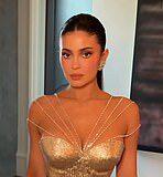 Glamorous woman in gold dress at a formal event.