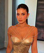 Glamorous woman in gold dress at a formal event.