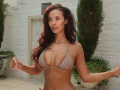 Brunette woman in bikini by poolside, outdoor setting with greenery and white wall.