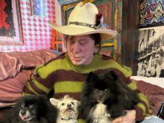 Pet-loving woman with three dogs in cozy room, showcasing a bond with her pets.
