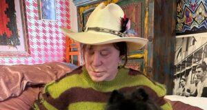 Pet-loving woman with three dogs in cozy room, showcasing a bond with her pets.