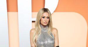 Elegant silver gown with black gloves on a glamorous woman at a fashion event.