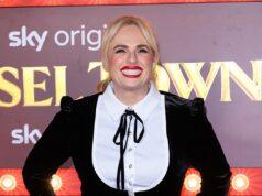 Blonde woman in black dress smiling at Lanka News Room event, showcasing fashion and entertainment coverage.