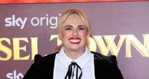 Blonde woman in black dress smiling at Lanka News Room event, showcasing fashion and entertainment coverage.