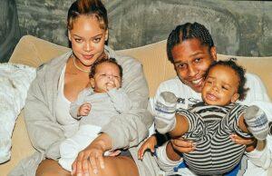 Happy family with young children smiling, sitting on a sofa indoors.