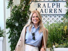 Elegant woman in Ralph Lauren outfit at shopping mall or boutique, smiling and holding a handbag.