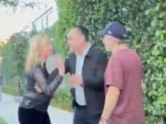 Distressed woman arguing with man on sidewalk, angry confrontation outside house, tension between individuals over a dispute.