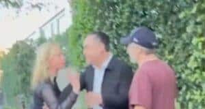 Distressed woman arguing with man on sidewalk, angry confrontation outside house, tension between individuals over a dispute.