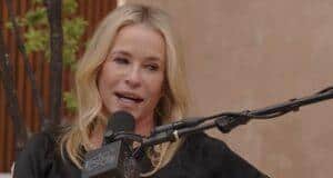 Blonde woman speaking into microphone during outdoor interview or podcast session.