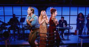 Performers on stage during a theatrical show in a vibrant, modern setting with live musicians in the background.