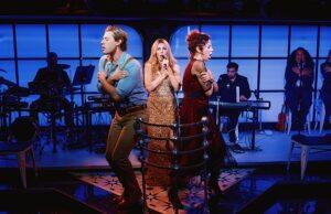 News Room : West End musical Titanique mocks Beckham family feud during first anniversary gala – after Brooklyn’s bombshell statement Performers on stage during a theatrical show in a vibrant, modern setting with live musicians in the background.